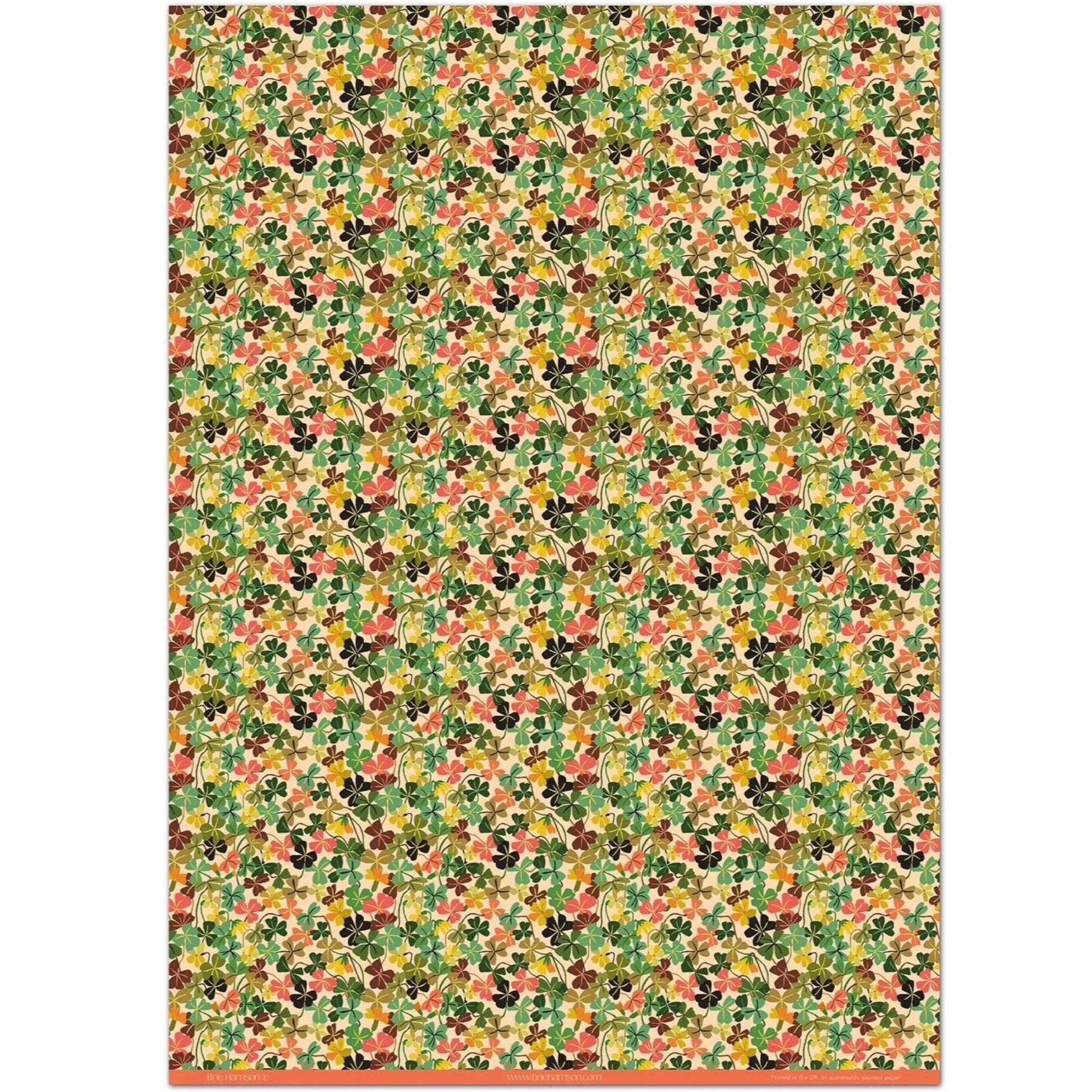 a sheet of wrapping paper with a stylised pattern of wood sorrel flowers in palette of pink, green and mustard