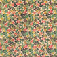 a sheet of wrapping paper with a stylised pattern of wood sorrel flowers in palette of pink, green and mustard