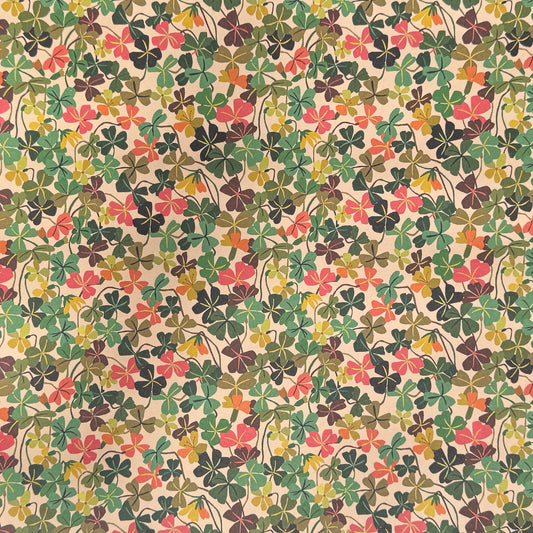 a sheet of wrapping paper with a stylised pattern of wood sorrel flowers in palette of pink, green and mustard
