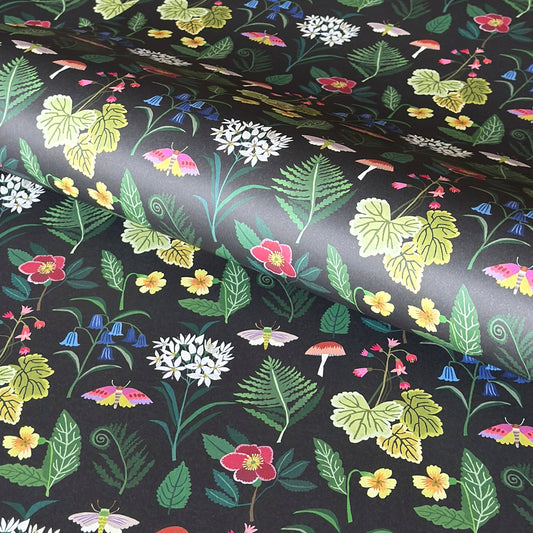  a sheet of wrapping paper with a black background and multl-colour flowers and fauna  from a woodland in bright colours
