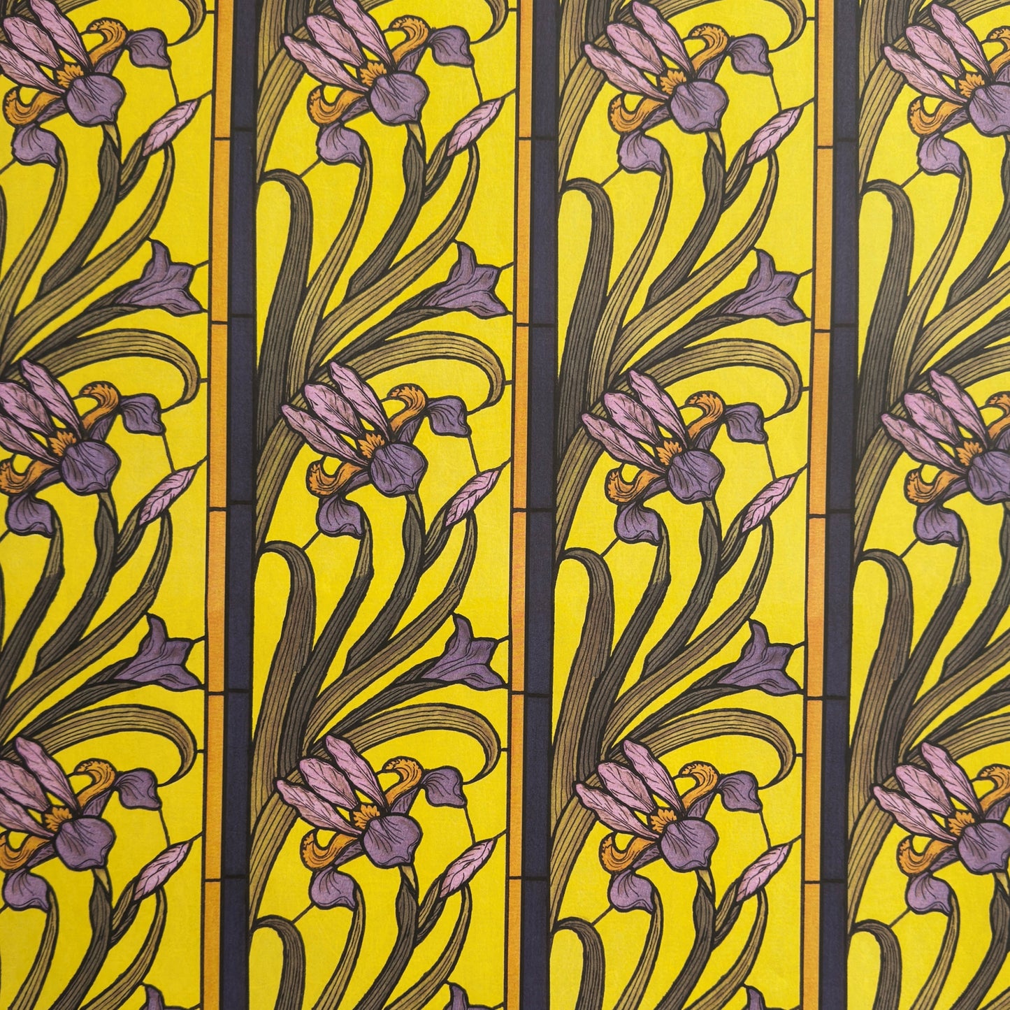 wrapping paper with a stylised pattern of lilac irises on a yellow background