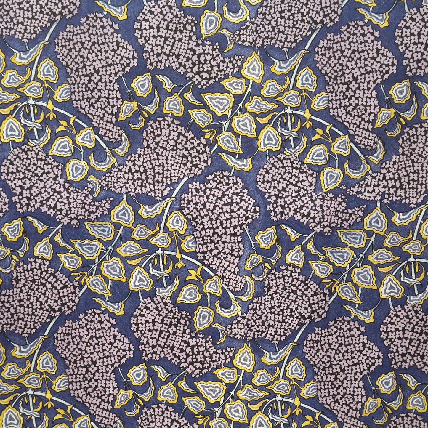 wrapping paper with a stylised lilac flower pattern in lilac , yellow and white