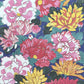 wrapping paper with a macro  design of an abundance of peonies and chrysanthemums in pink, red, yellow on a dark blue backdrop