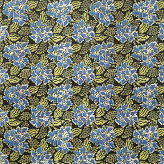 a sheet of wrapping paper with a stylised periwinkle flower design in blue and green on black