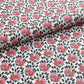 wrapping paper with a repeat design of pink flowers, black seedheads on white 