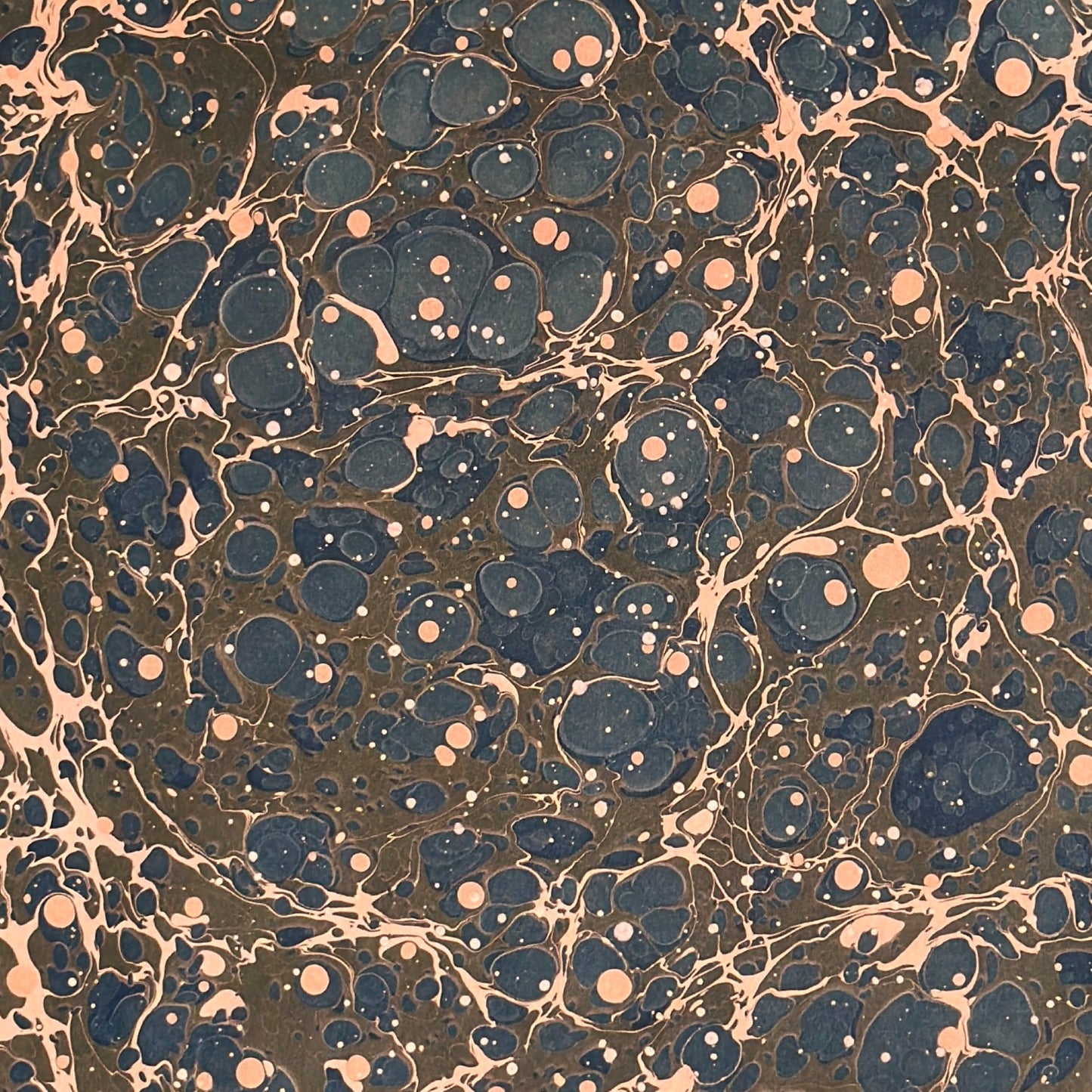 A printed marble design wrapping paper in tones of brown, blue and soft coral pink.