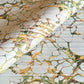 Printed marbled gift wrapping paper by Compton Marbling with a stone marbling pattern in soft grey, green and mustard.
