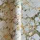 Printed marbled gift wrapping paper by Compton Marbling with a stone marbling pattern in soft grey, green and mustard.