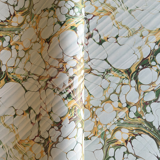 Printed marbled gift wrapping paper by Compton Marbling with a stone marbling pattern in soft grey, green and mustard.