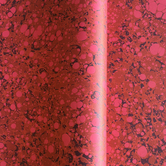 printed wrapping paper with a marbled stone pattern in deep reds and pinks by Compton Marbling