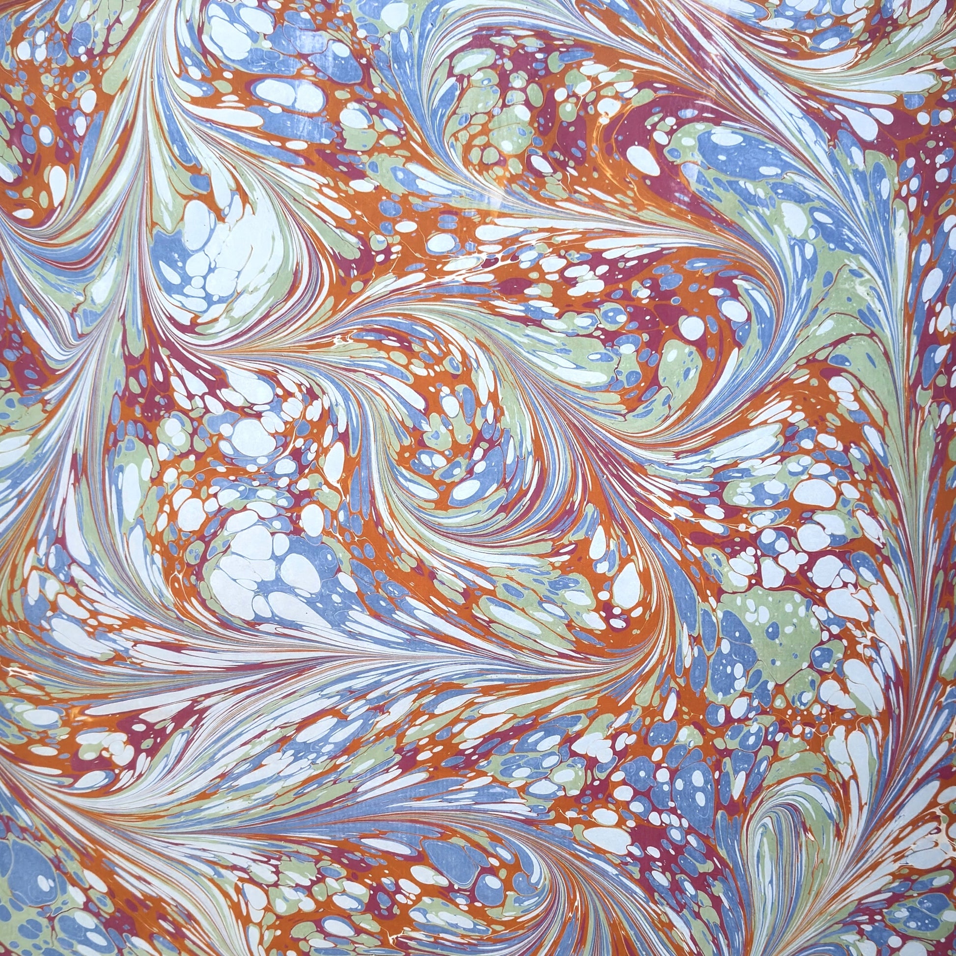 printed marble wrapping paper with a swirl design in blue, orange, green and pink. By Compton Marbling