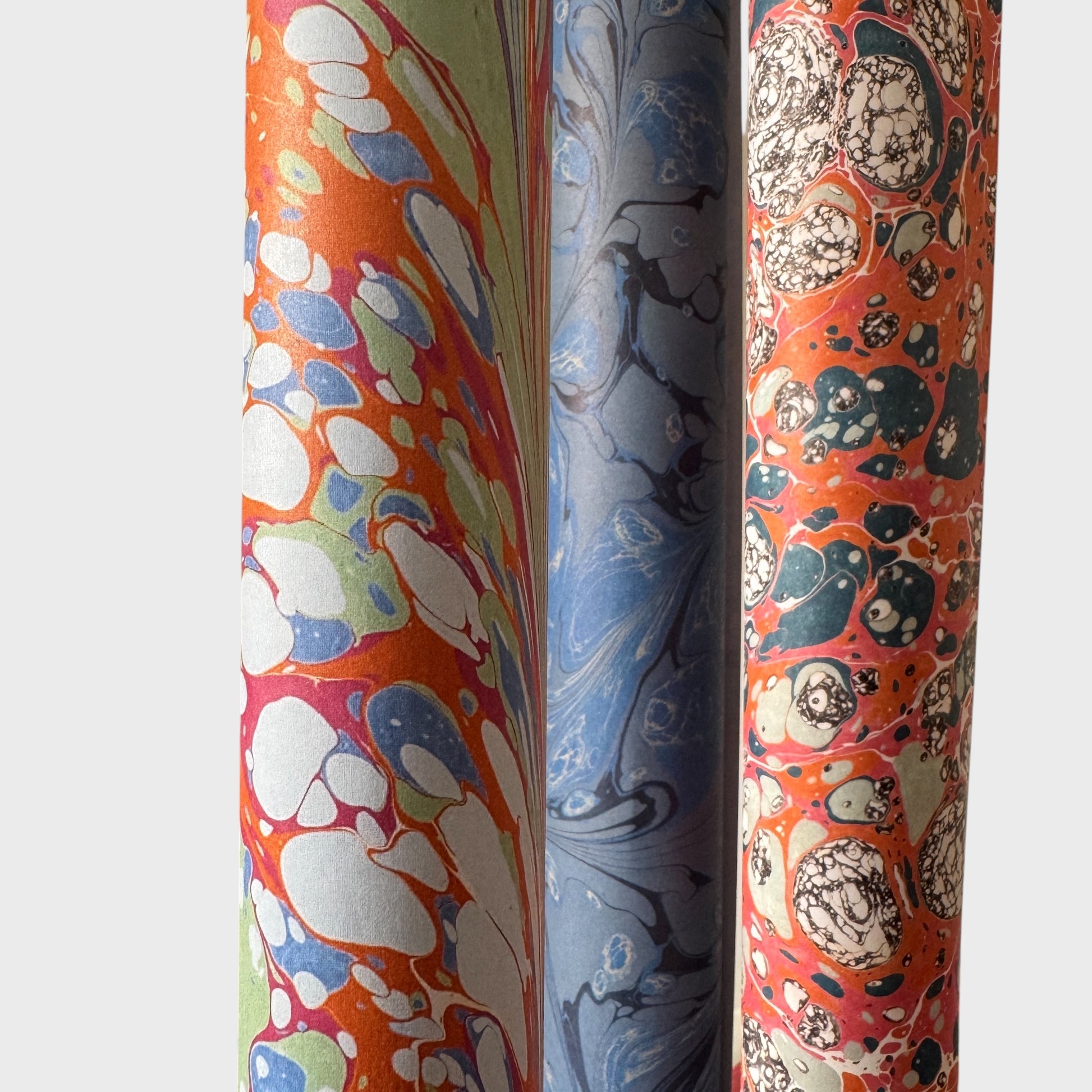 printed marble wrapping paper with a swirl design in blue, orange, green and pink. By Compton Marbling. Close up