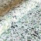 marbled printed wrapping paper with spot design in moss green, pale pink on a soft green.