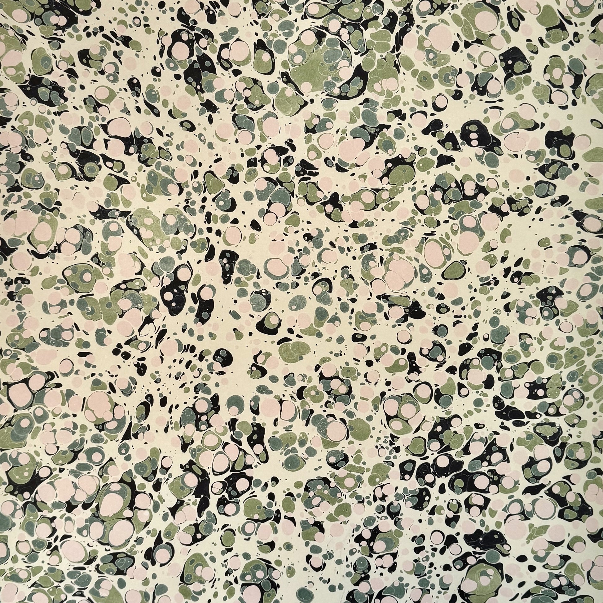 marbled printed wrapping paper with spot design in moss green, pale pink on a soft green