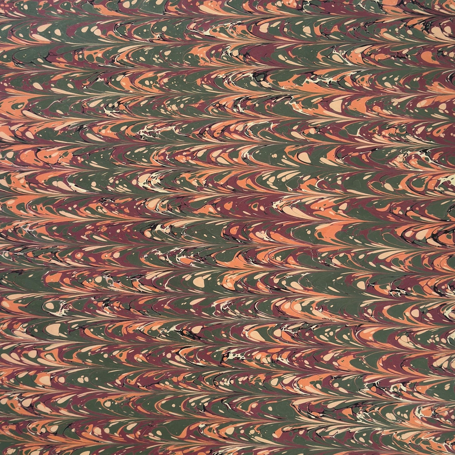 Printed marbled gift wrapping paper by Compton Marbling with a ripple marbled pattern in soft green, burgundy, cream and amber