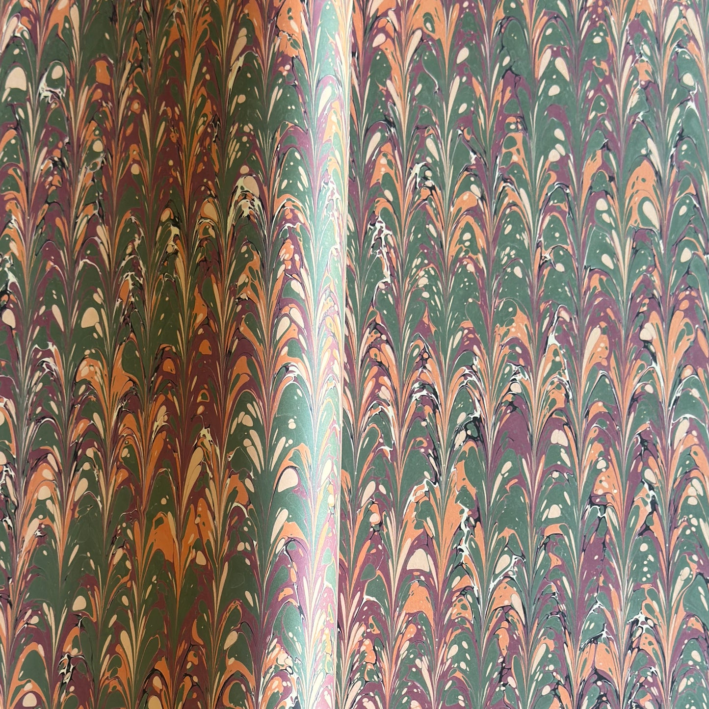 Printed marbled gift wrapping paper by Compton Marbling with a ripple marbled pattern in soft green, burgundy, cream and amber