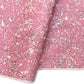 a sheet of wrapping paper with a pink marbled pattern with white and black veined design