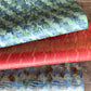 three sheets of wrapping paper with paste paper designs in greens, blue and reds