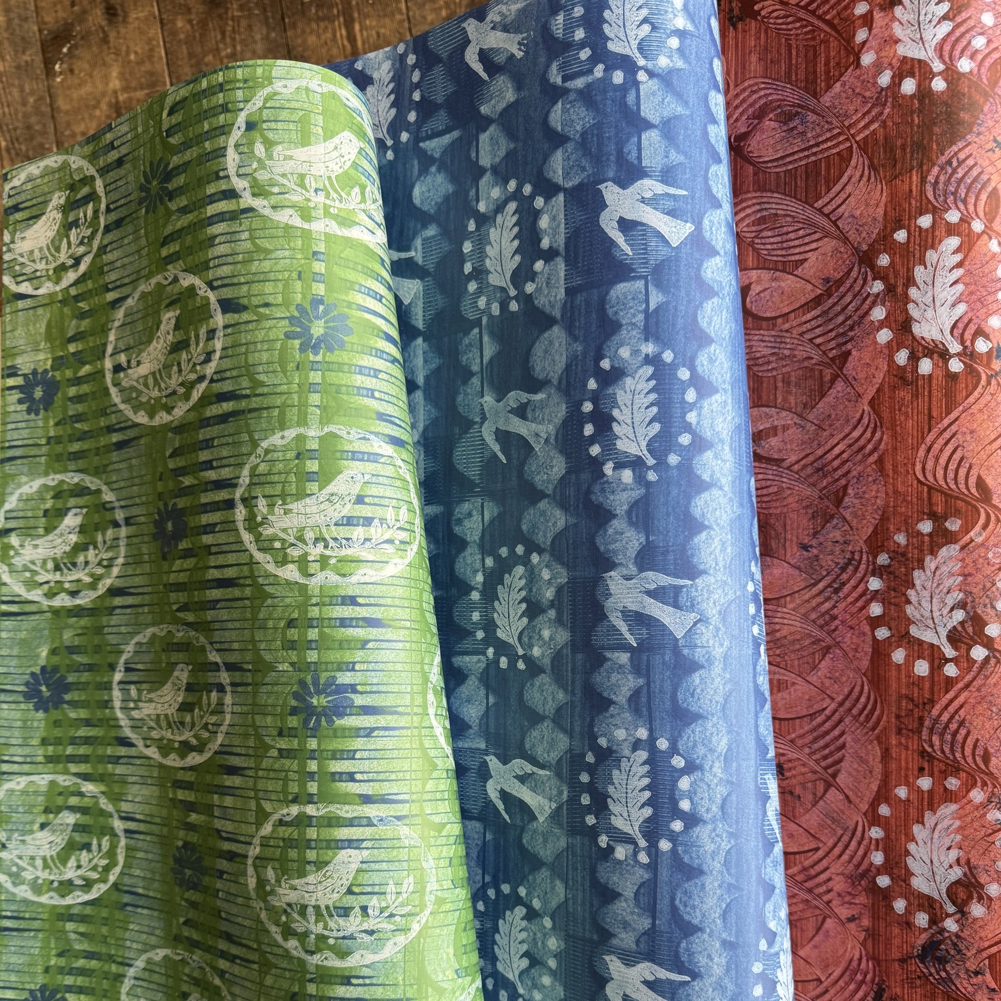 three sheets of wrapping paper by Elizabeth Harbour from the Danby Press. Each has a paste paper background with relief print