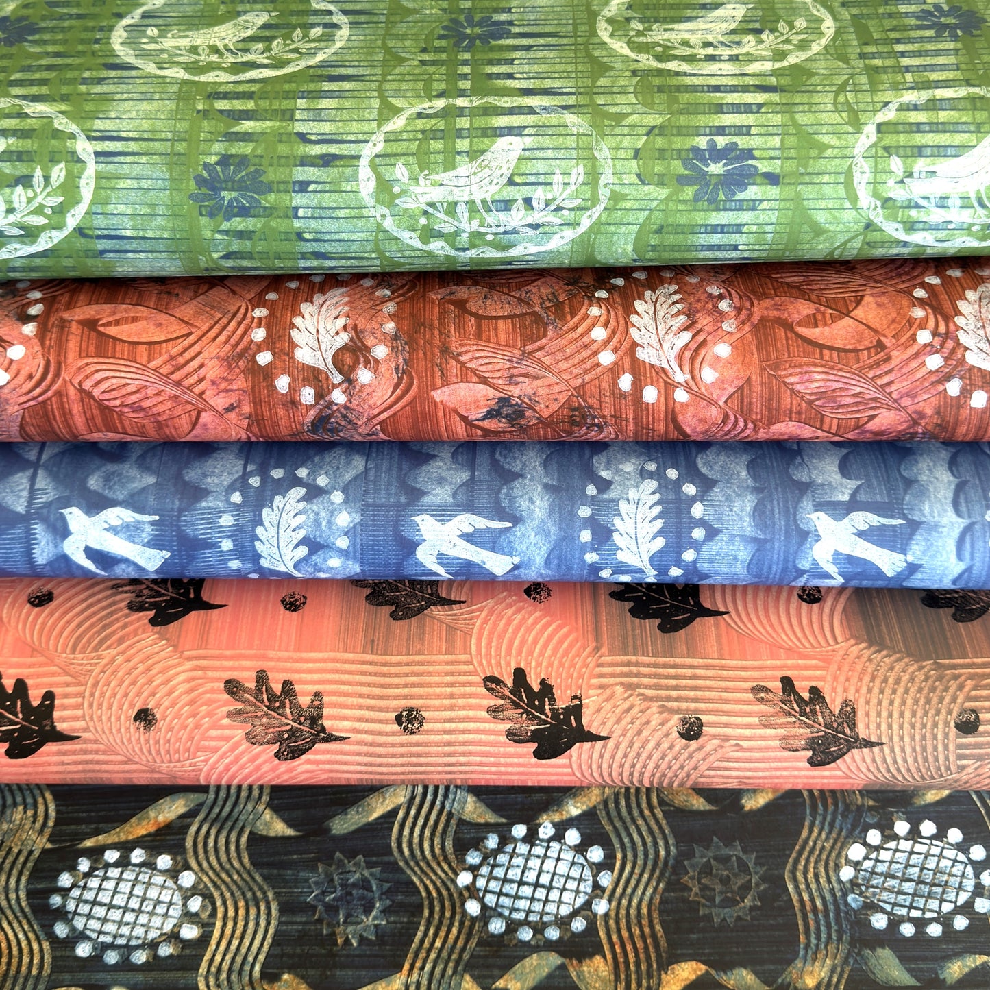five sheets of patterned wrapping papers from Danby Press, with painterly designs of paste papers and relief prints.