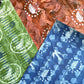 a sheet of wrapping paper from the Danby Press with a  backdrop of green paste paper design and circular stamped white bird motifs. Pictured with other painterly designs