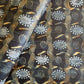  a sheet of wrapping paper with a relief printed star and flower in white on a inky blue paste paper backdrop