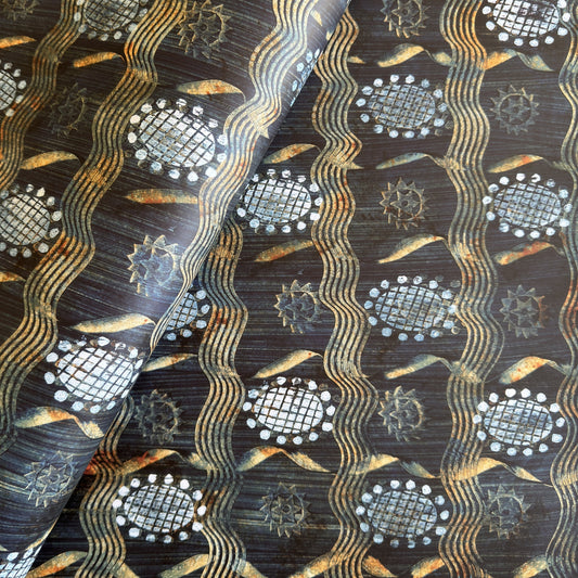  a sheet of wrapping paper with a relief printed star and flower in white on a inky blue paste paper backdrop