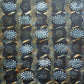  a sheet of wrapping paper with a relief printed star and flower in white on a inky blue paste paper backdrop