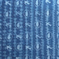 a sheet of wrapping paper with a relief printed oak leaf and bird in white on a blue paste paper backdrop