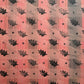  a sheet of wrapping paper with a relief printed black oak leaf on a coral pink paste paper backdrop