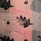  a sheet of wrapping paper with a relief printed black oak leaf on a coral pink paste paper backdrop