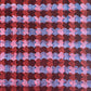 a sheet of wrapping paper with an abstract block print in dark red, pink and blue