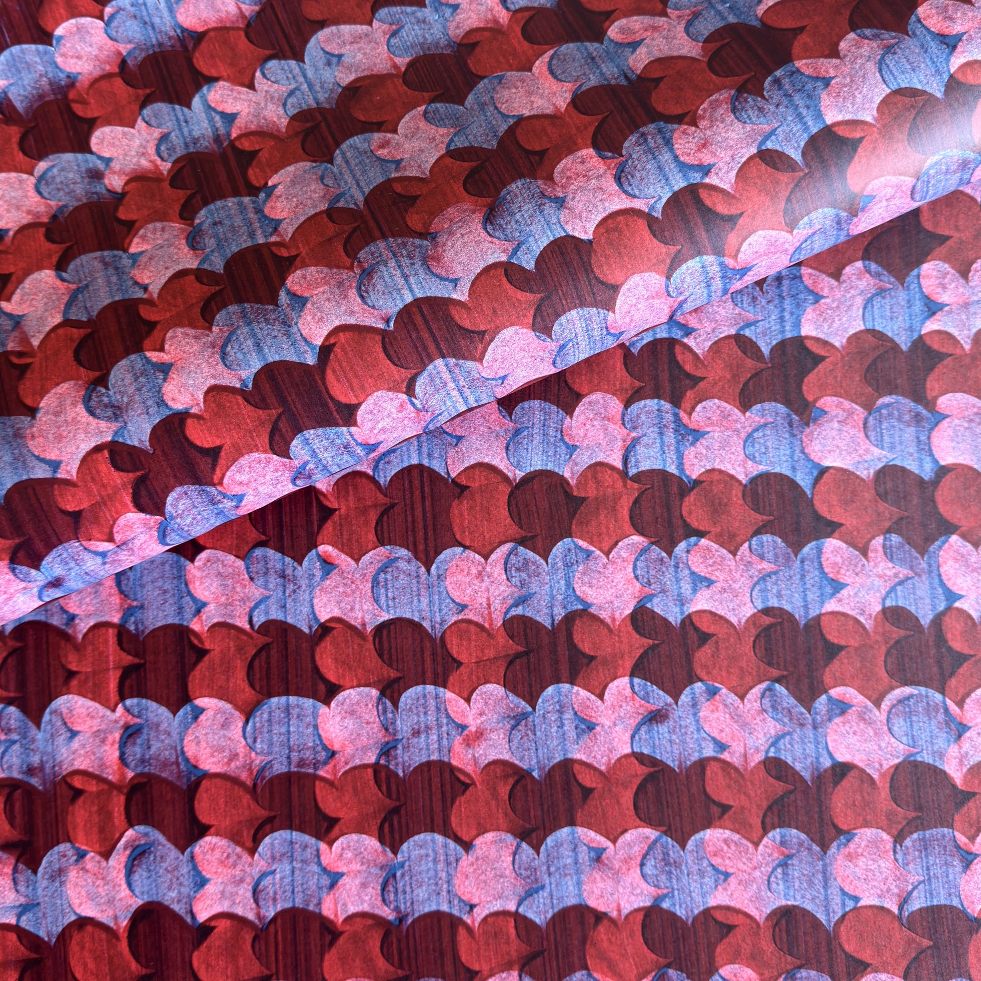 a sheet of wrapping paper with an abstract block print in dark red, pink and blue