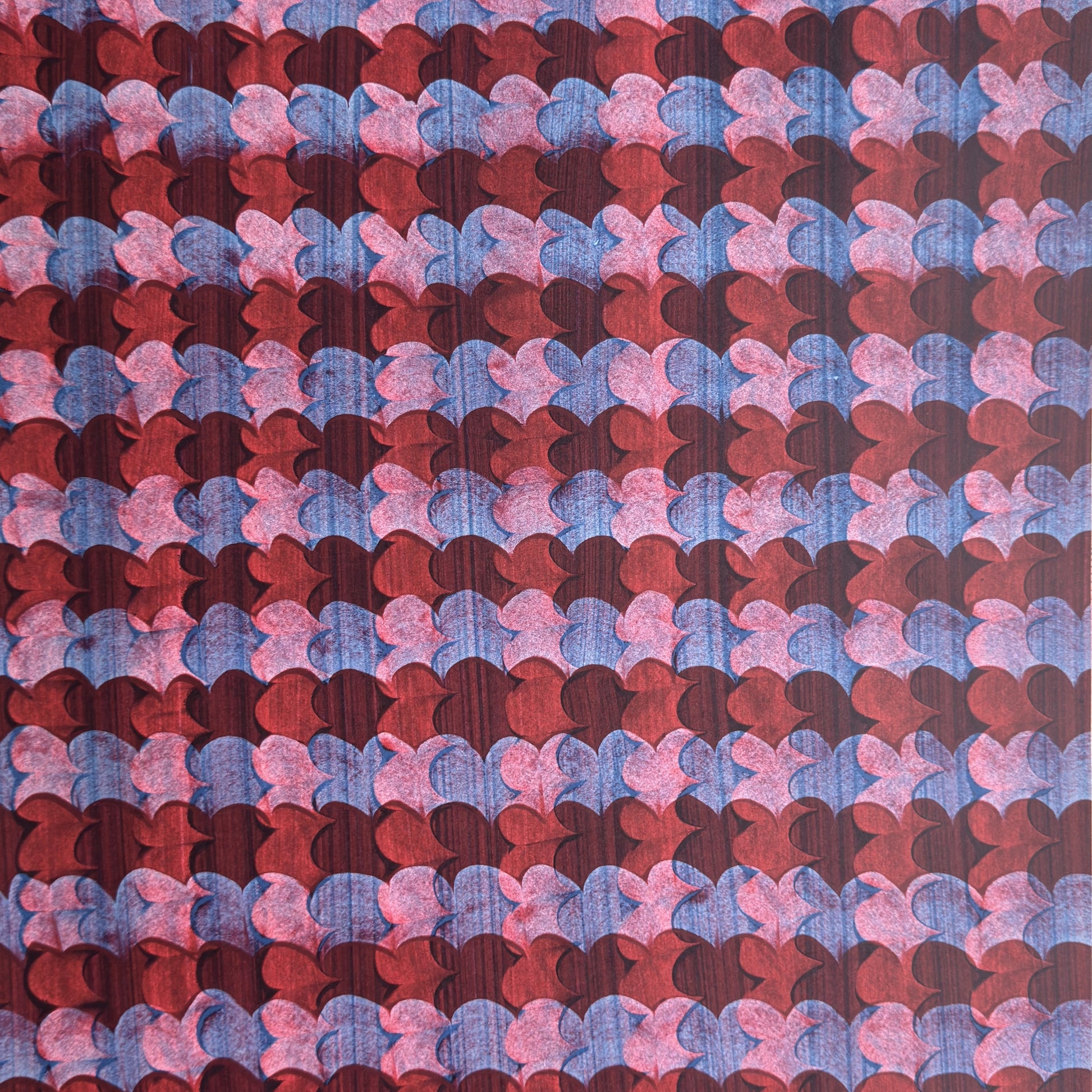 a sheet of wrapping paper with an abstract block print in dark red, pink and blue