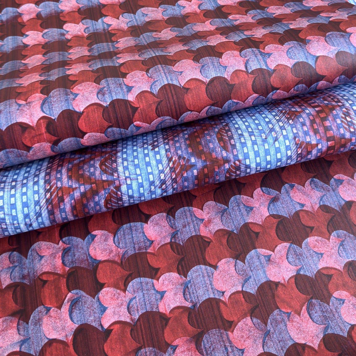a sheet of wrapping paper with an abstract block print in dark red, pink and blue