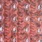 a sheet of wrapping paper with a relief printed oak leaf in white on a rust brown paste paper backdrop