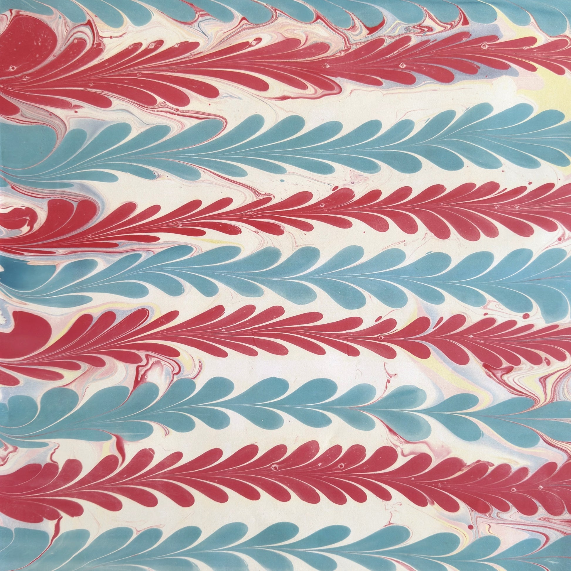 a sheet of wrapping paper with a marbled design in pink, blue and white