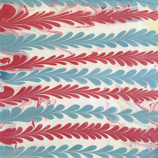 a sheet of wrapping paper with a marbled design in pink, blue and white