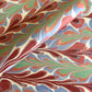 a sheet of wrapping paper with a marbled design in pink, blue, green and red