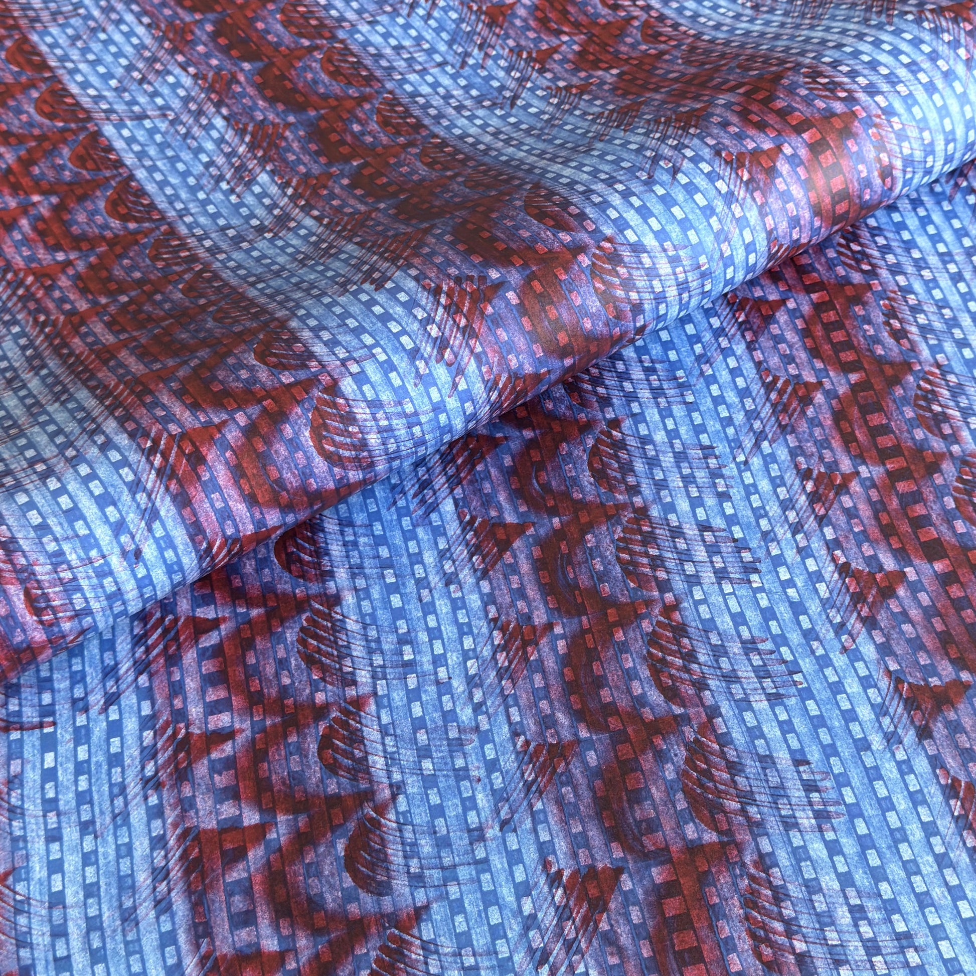 a sheet of wrapping paper with a paste paper style design in blue and dark red