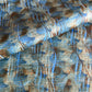 a sheet of wrapping paper with a paste paper style design in blue and brown