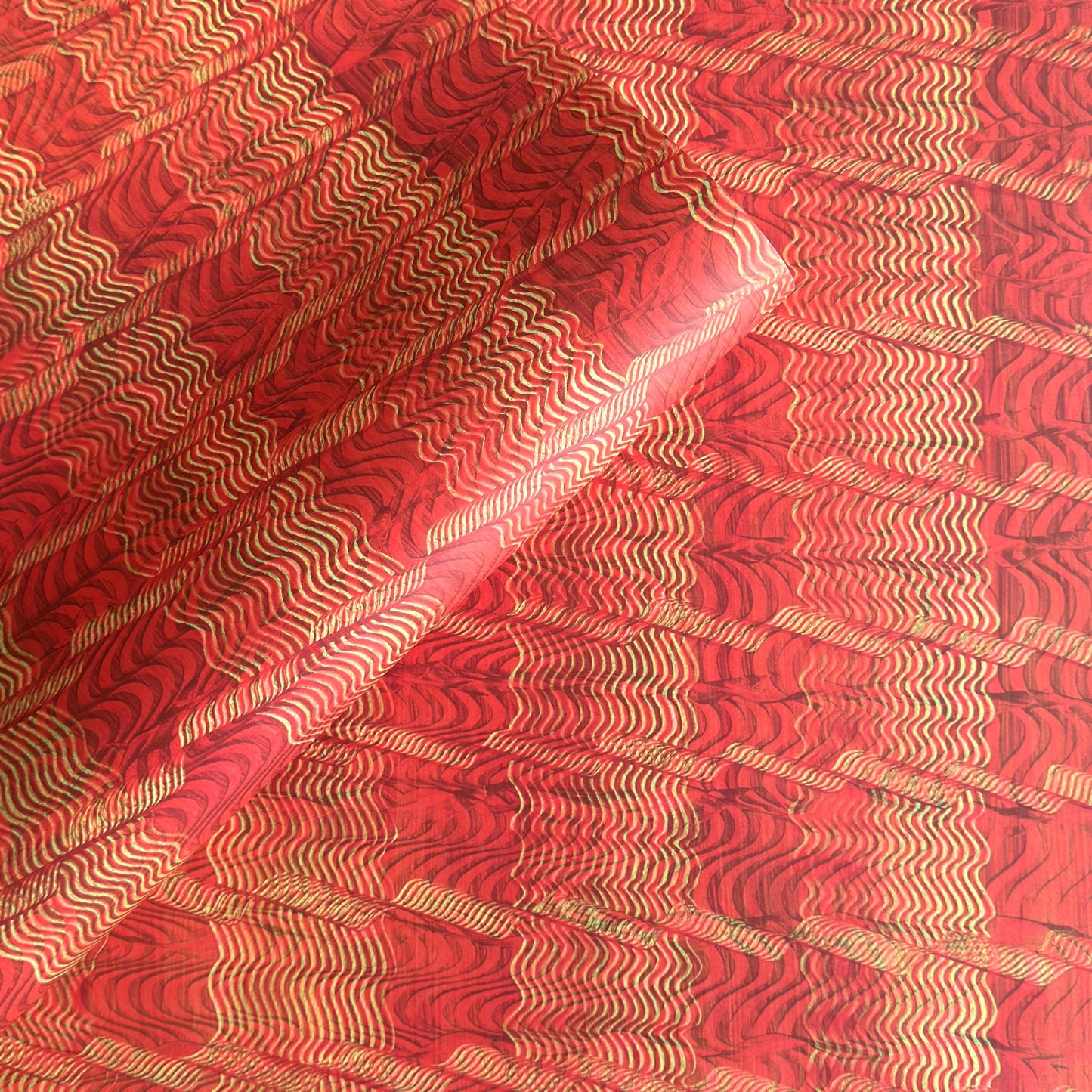 a sheet of wrapping paper with a paste paper style design in red and yellow