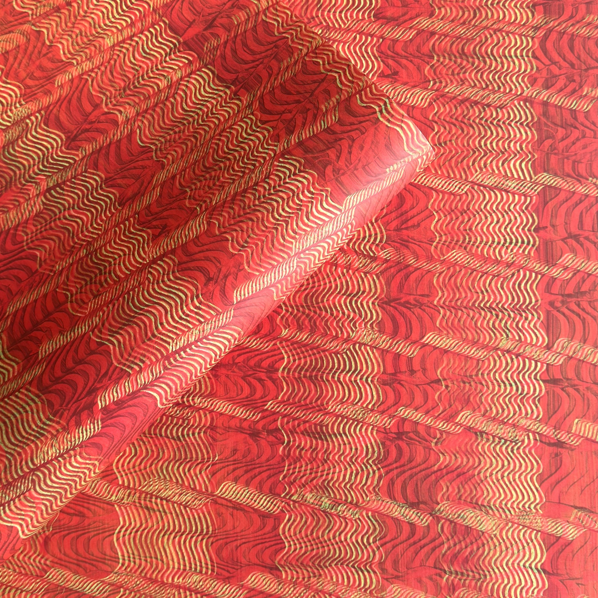 a sheet of wrapping paper with a paste paper style design in red and yellow