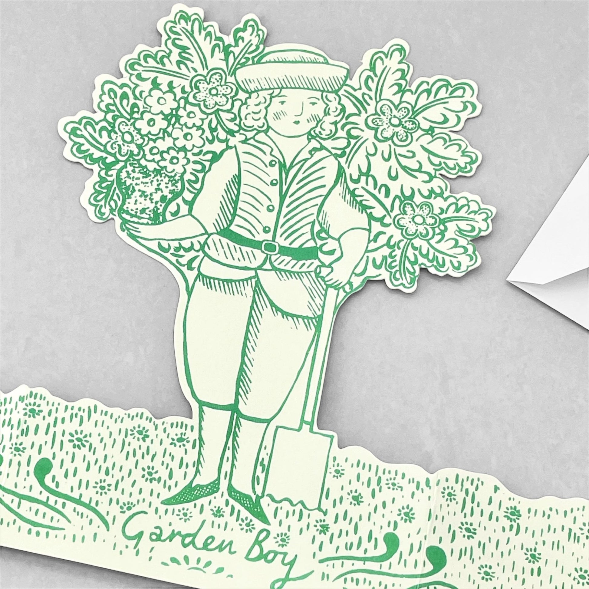 A cut-out and stand up greetings card of a garden boy next to a small tree, by Elizabeth Harbour