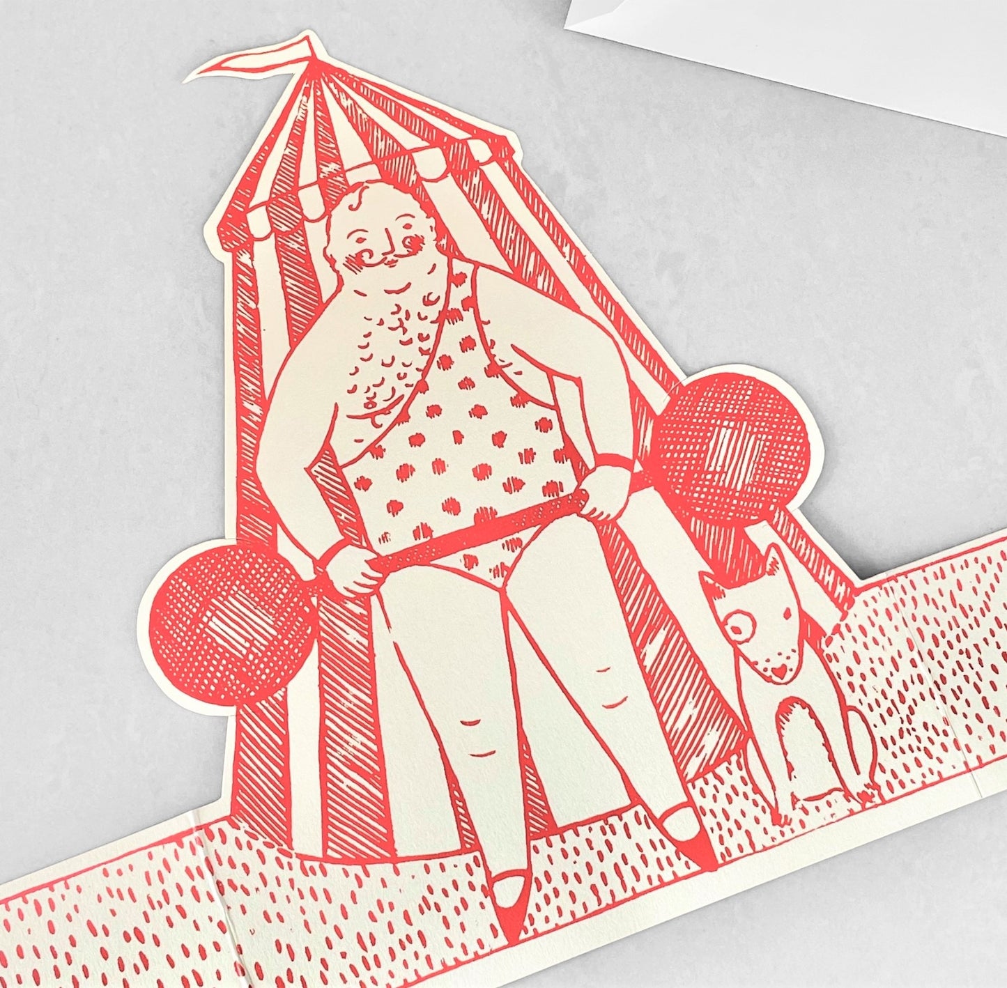 A cut-out and stand up greetings card of a circus strongman and dog, by Elizabeth Harbour