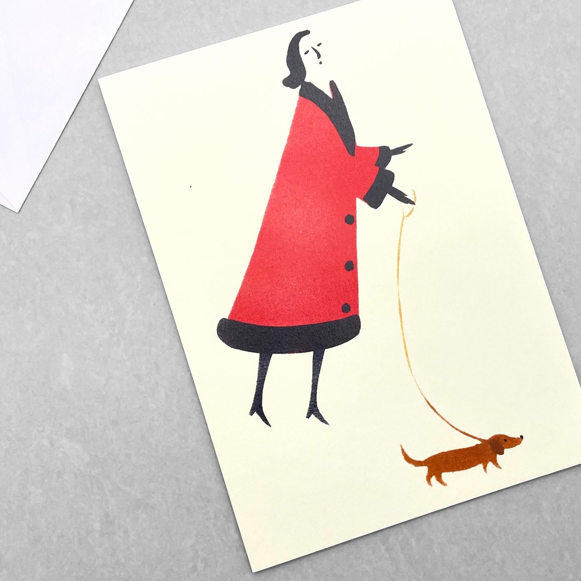 greetings card of a drawing of a women in a red coat walking a little dog by Elizabeth Harbour