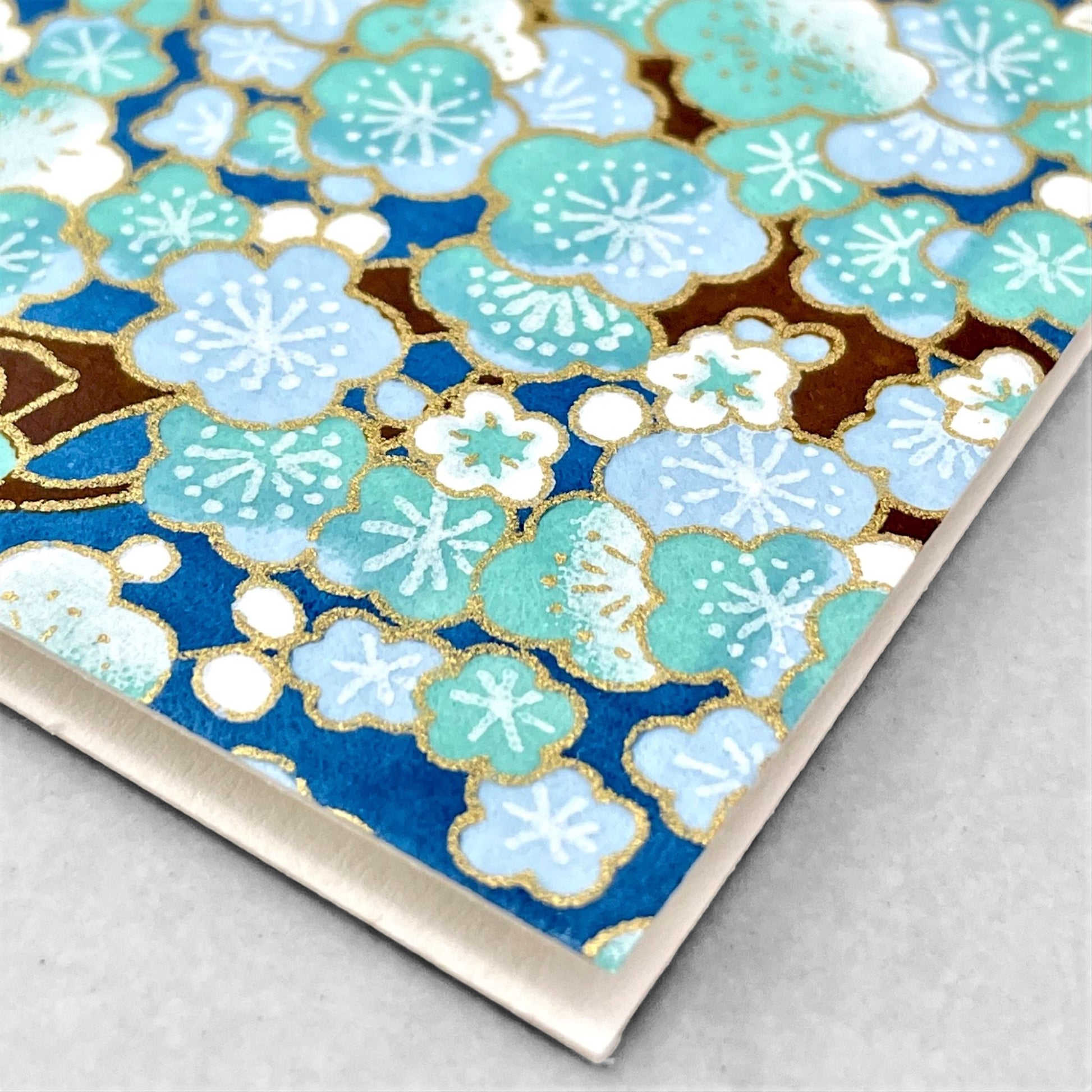 japanese silk-screen printed greetings card with a pattern of pale blue and white blossom on a blue backdrop by Esmie
