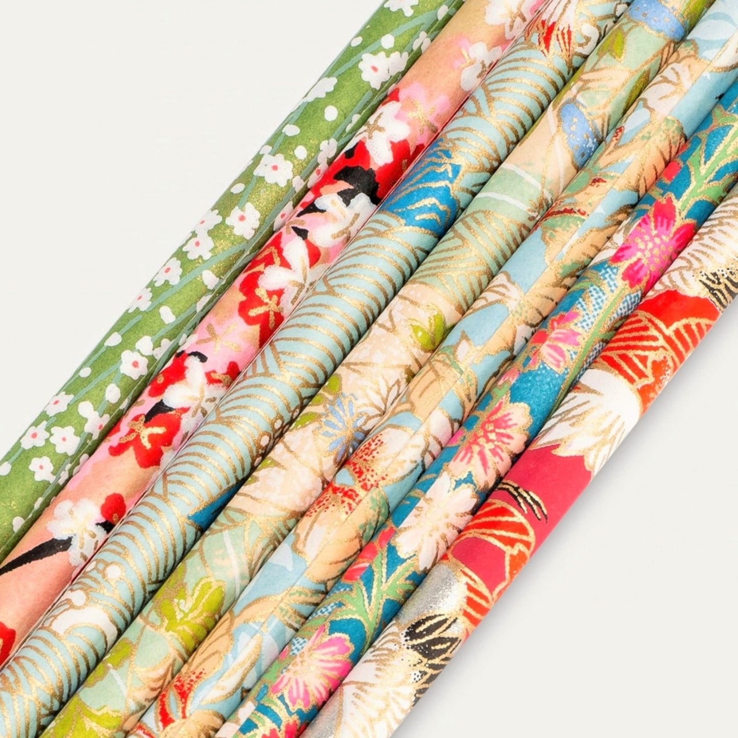 Set of seven pencils covered in assorted japanese silkscreen printed patterned papers , close-up of the patterns