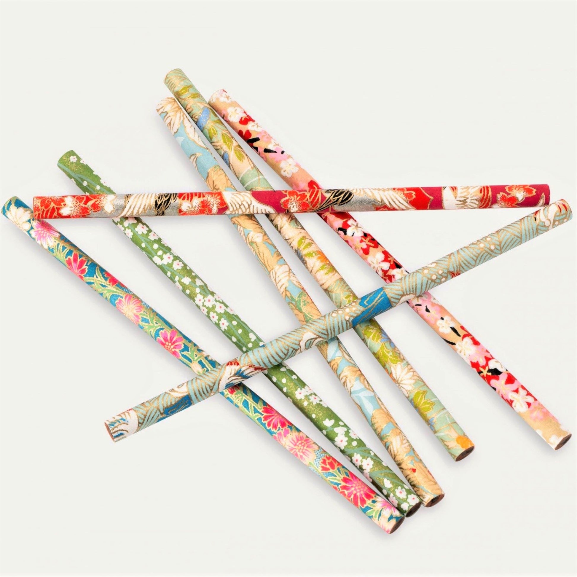 Set of seven pencils covered in assorted japanese silkscreen printed patterned papers , close-up of the patterns