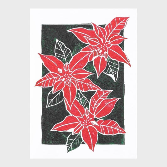 Greeting card with a linocut print of a poinsetta in red and green